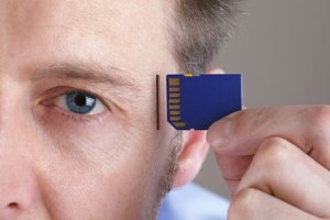 Inserting SD memory card into slot in human head concept for memory upgrade, forgetfulness or comput